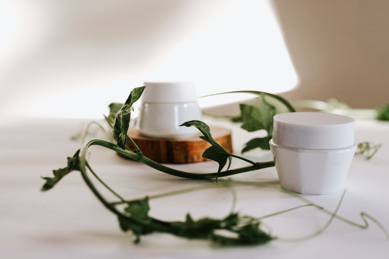 A plain white moisturiser jar on a neutral surface