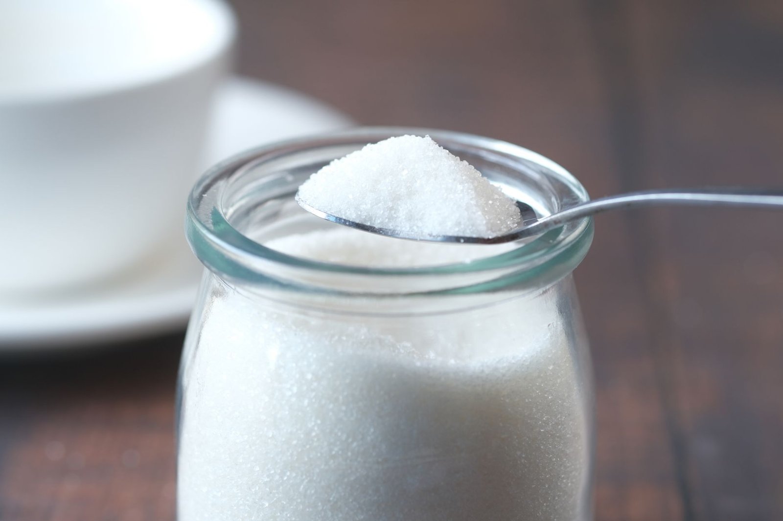 A jar of homemade body scrub with a wooden spoon