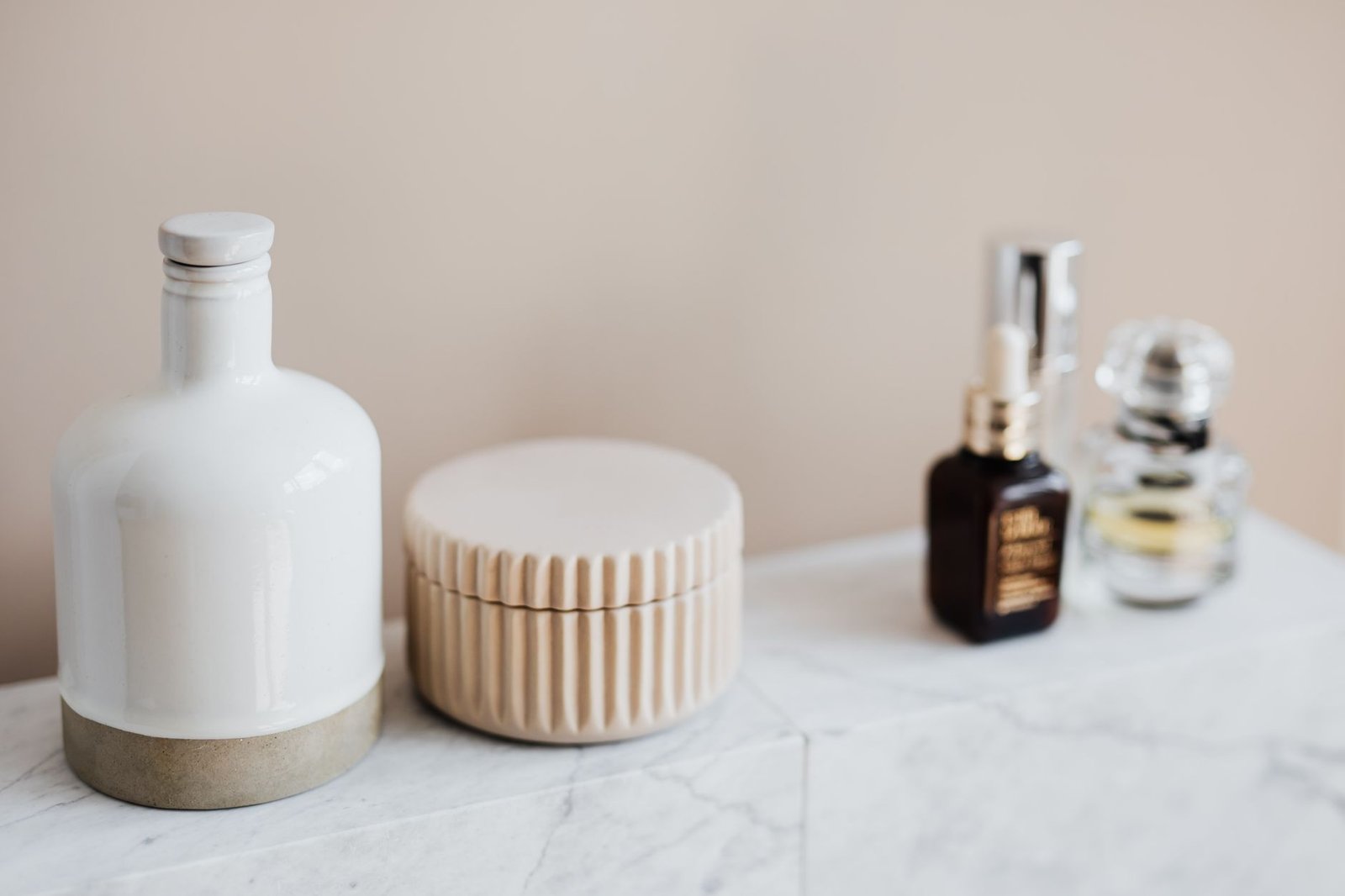 A short row of skincare products arranged on a bathroom shelf
